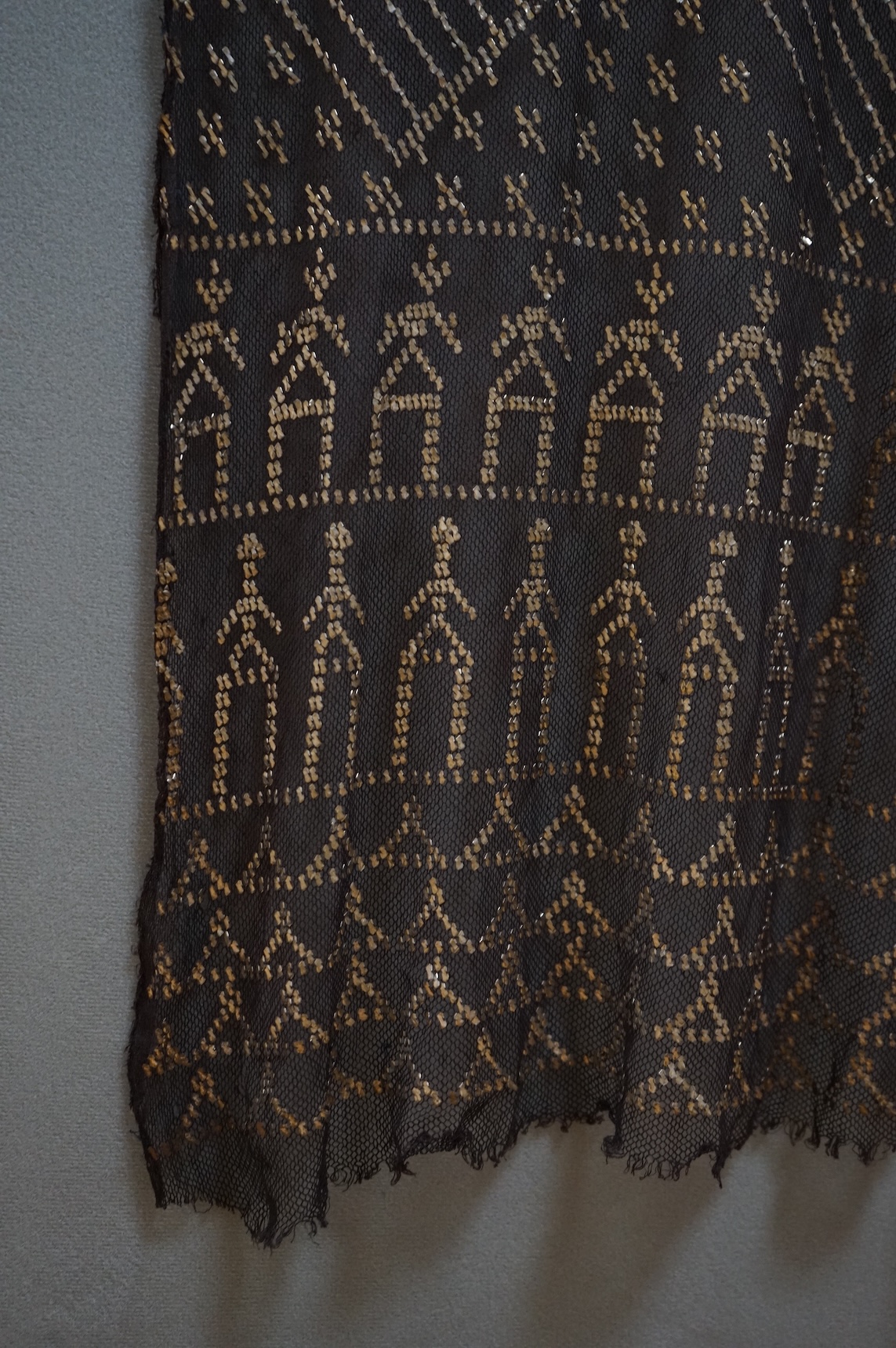 A 1930’s Egyptian decorative metal on black net evening stole. Approximately 218cm long. Condition - the rolled edges are frayed but the colour and design are intact.